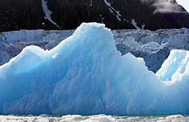 The angle of the Sun deepens the blue color of this small iceberg.
